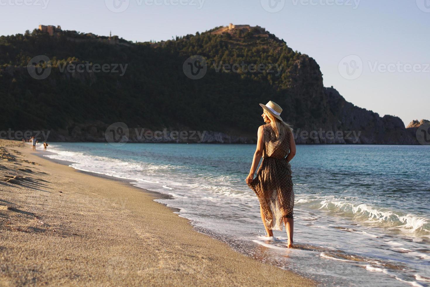 mujer en la playa con un vestido marrón foto