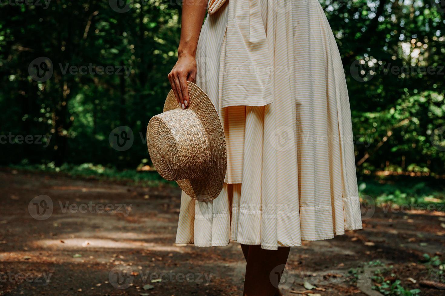 Close-up photo of a woman's hand holding a straw hat