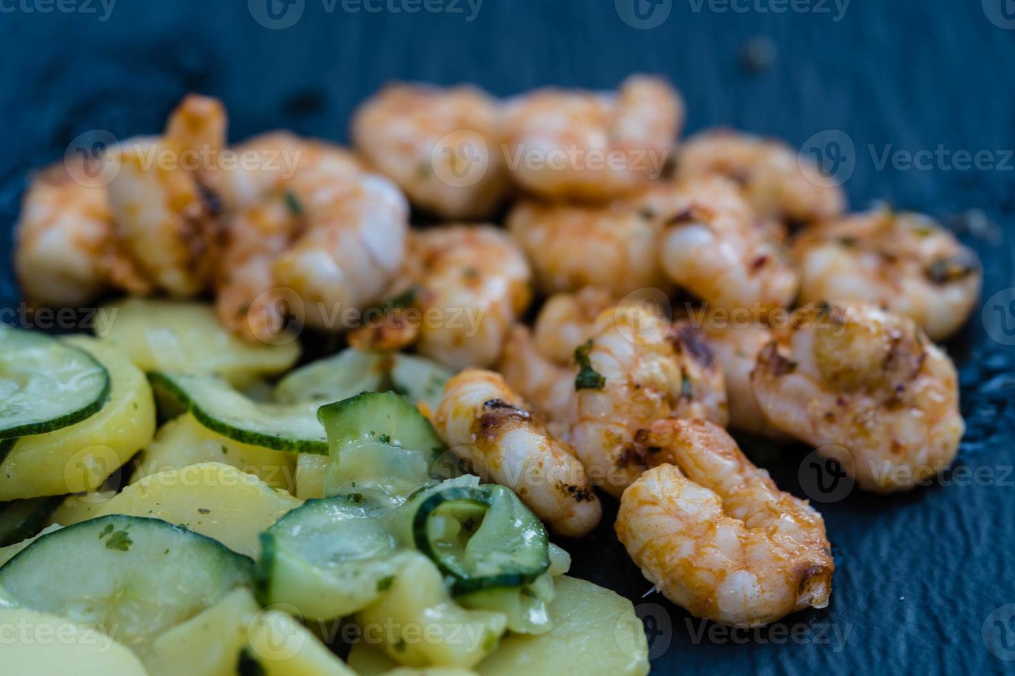 Spicy white tiger prawns from the grill with potato cucumber salad photo