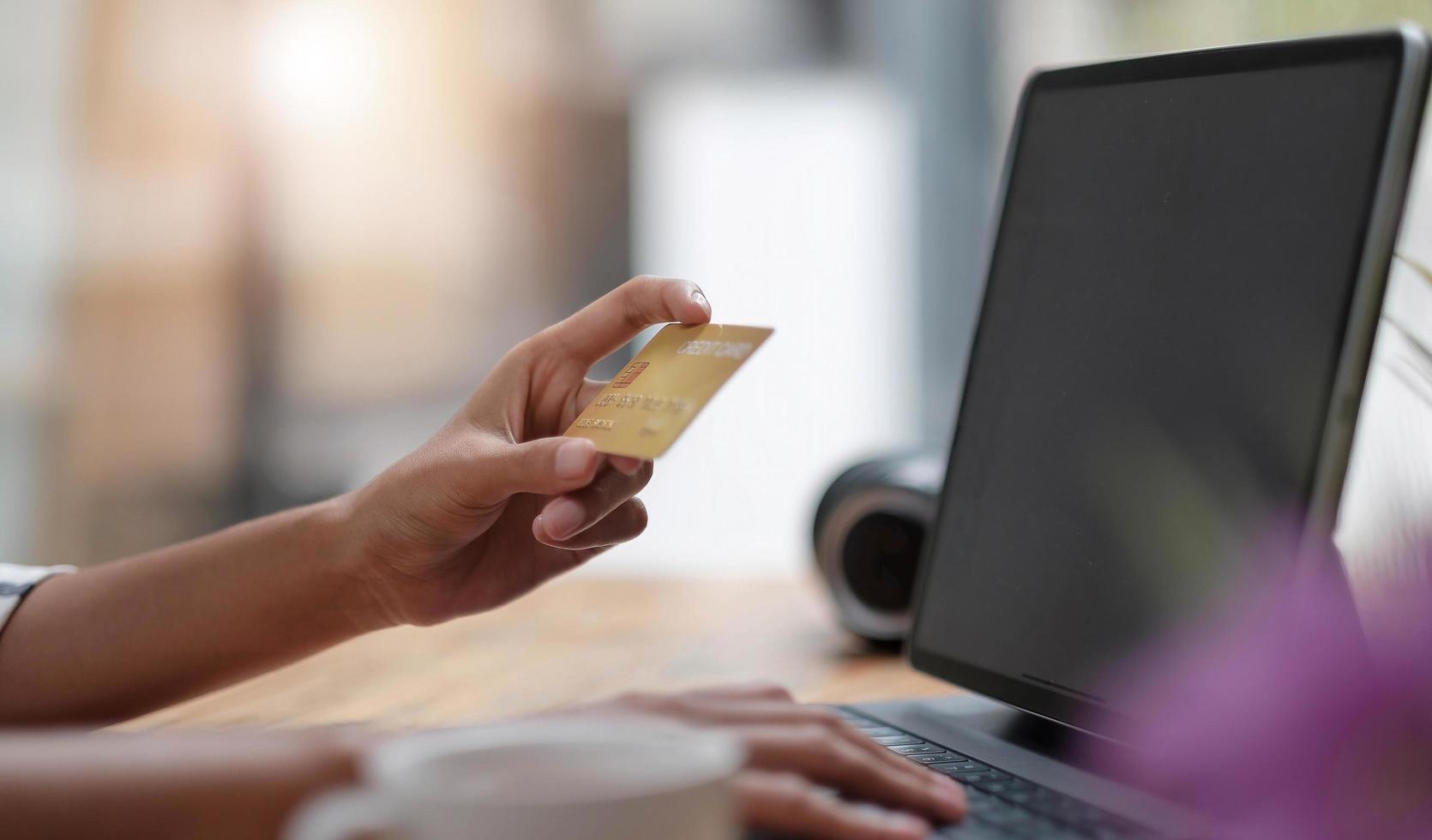 Cerrar chica en Internet en la tableta digital con tarjeta de crédito foto