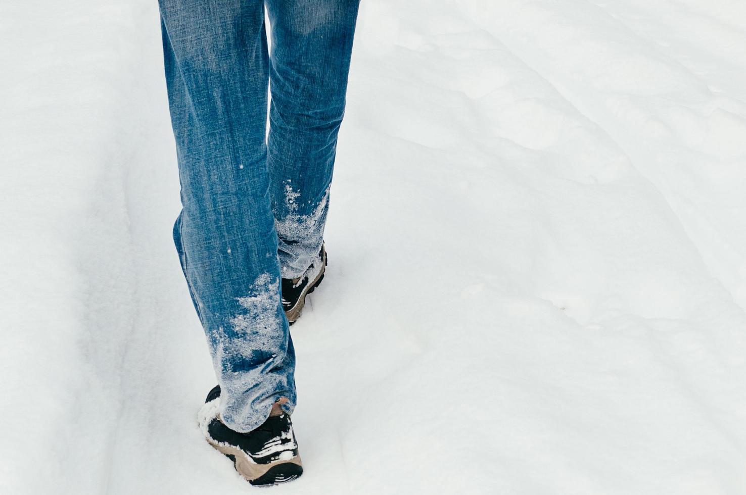 Back view of male legs walking in snow photo