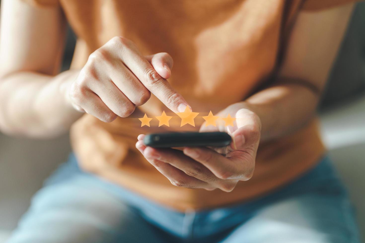 cliente mujer da cinco estrellas en el teléfono inteligente. calificación, satisfacción. foto