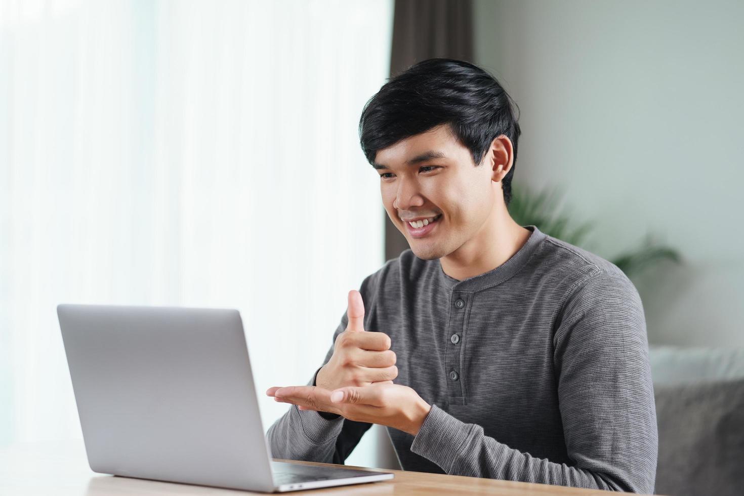 Deaf man use laptop video conference communicating in sign language. photo