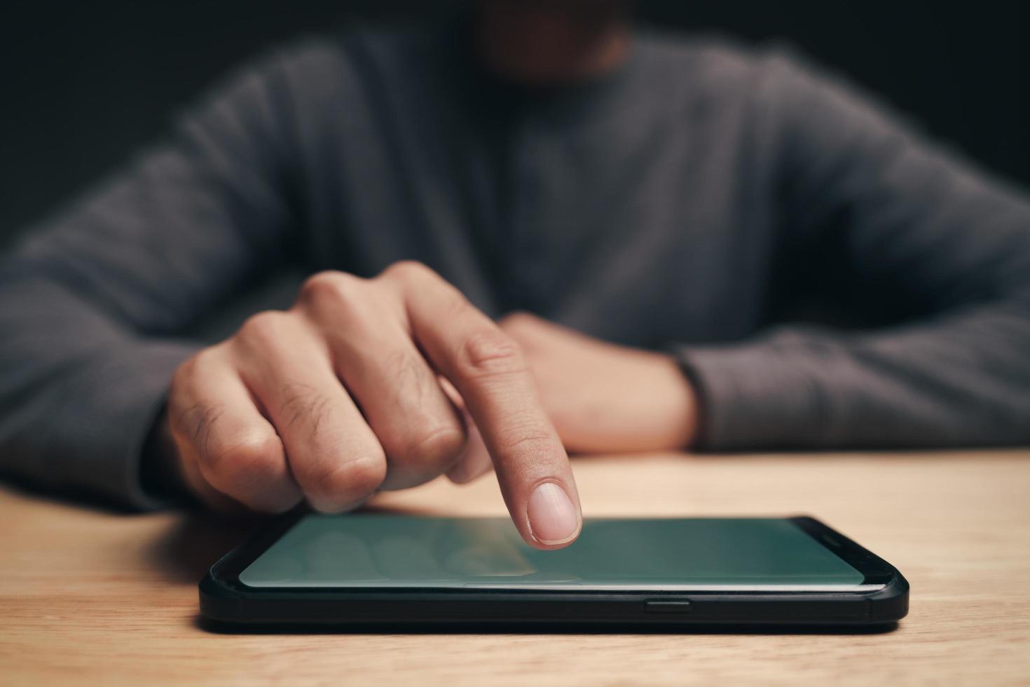 Man using a smartphone on the table, searching, browsing, social media photo