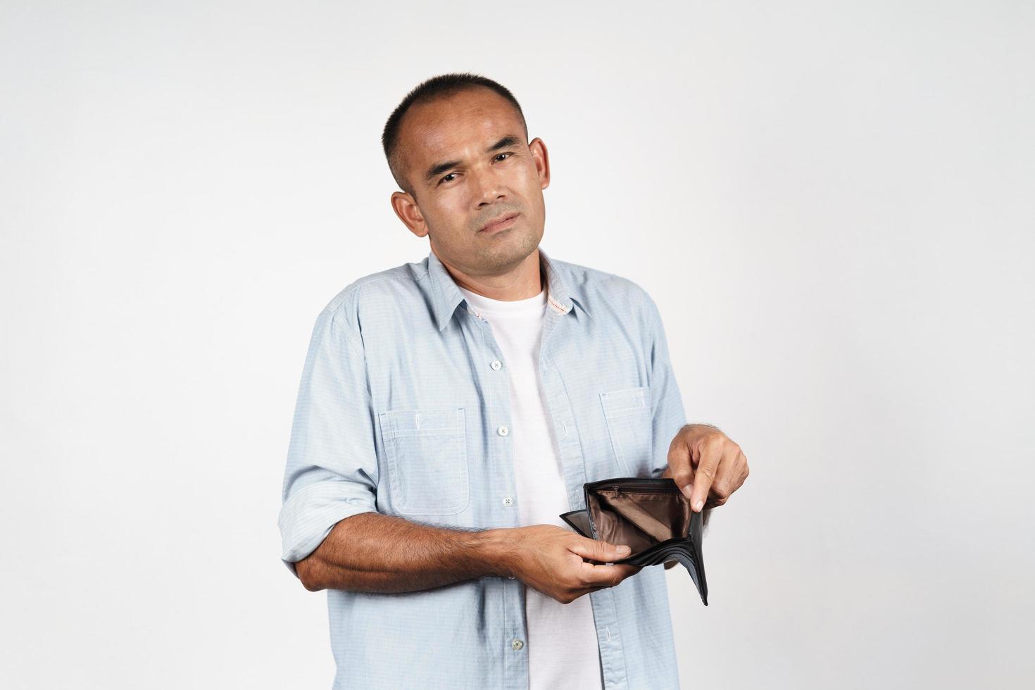 hombre sosteniendo su billetera vacía sobre fondo blanco. Sin dinero. foto