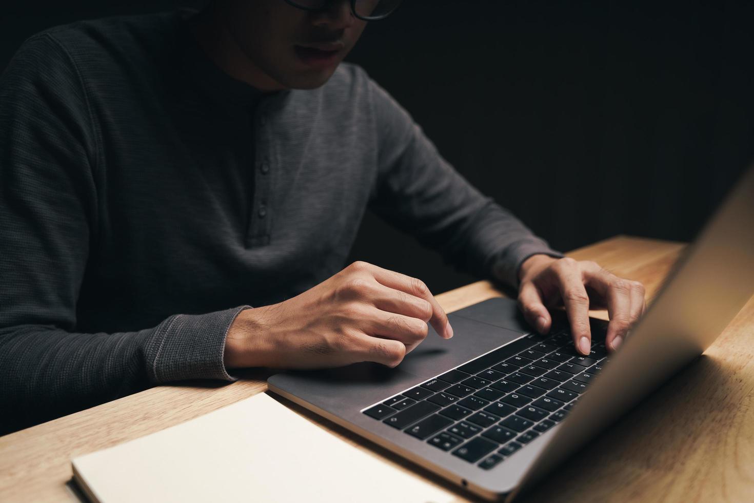 hombre usando laptop sobre la mesa, buscando, navegando, redes sociales. foto