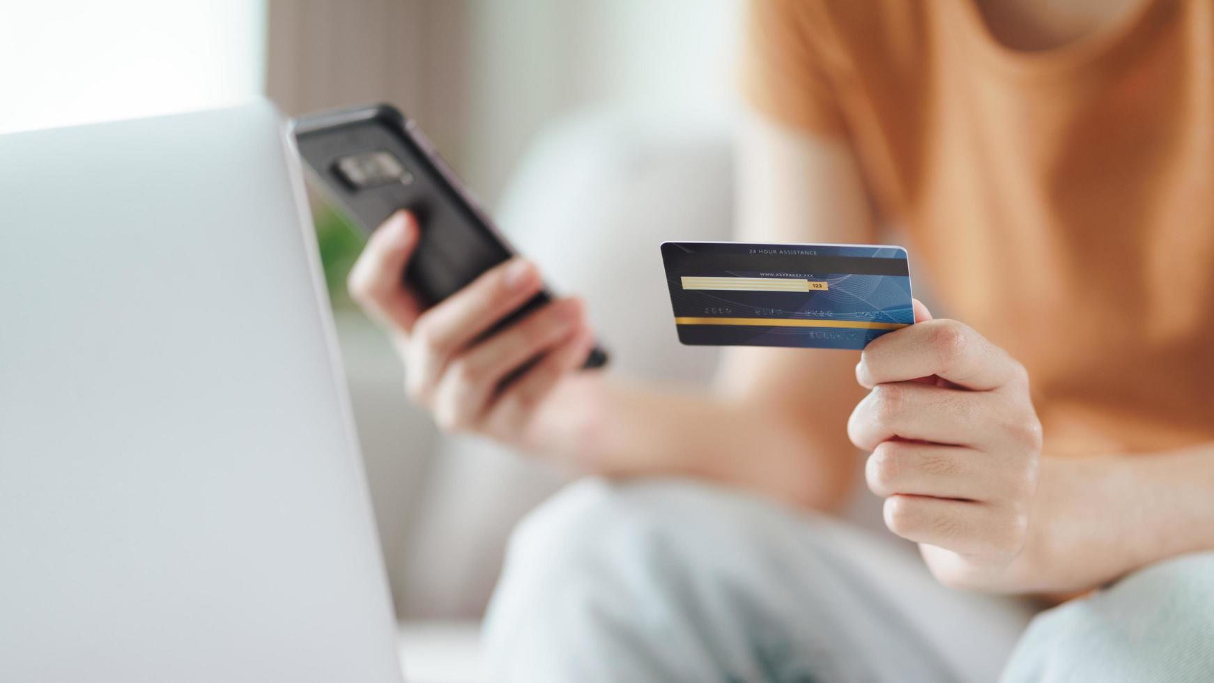 Woman holding credit card and using smart phone for online shopping. photo