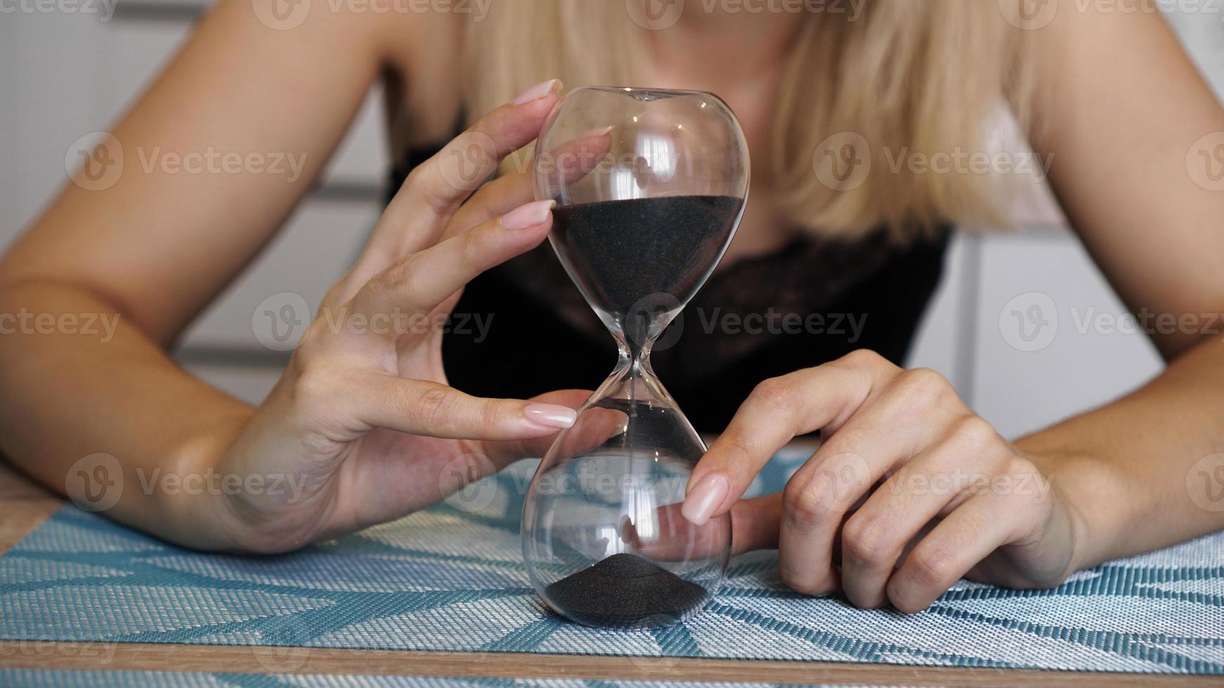 hombre tiene reloj de arena en la mano foto