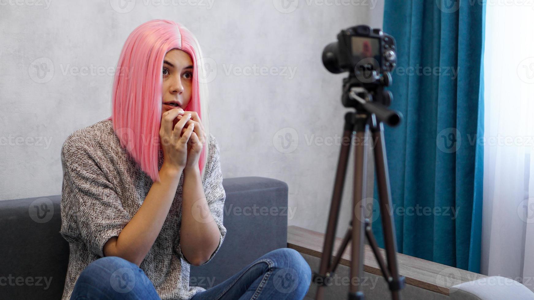 Young female blogger with camera vlogging stressed photo