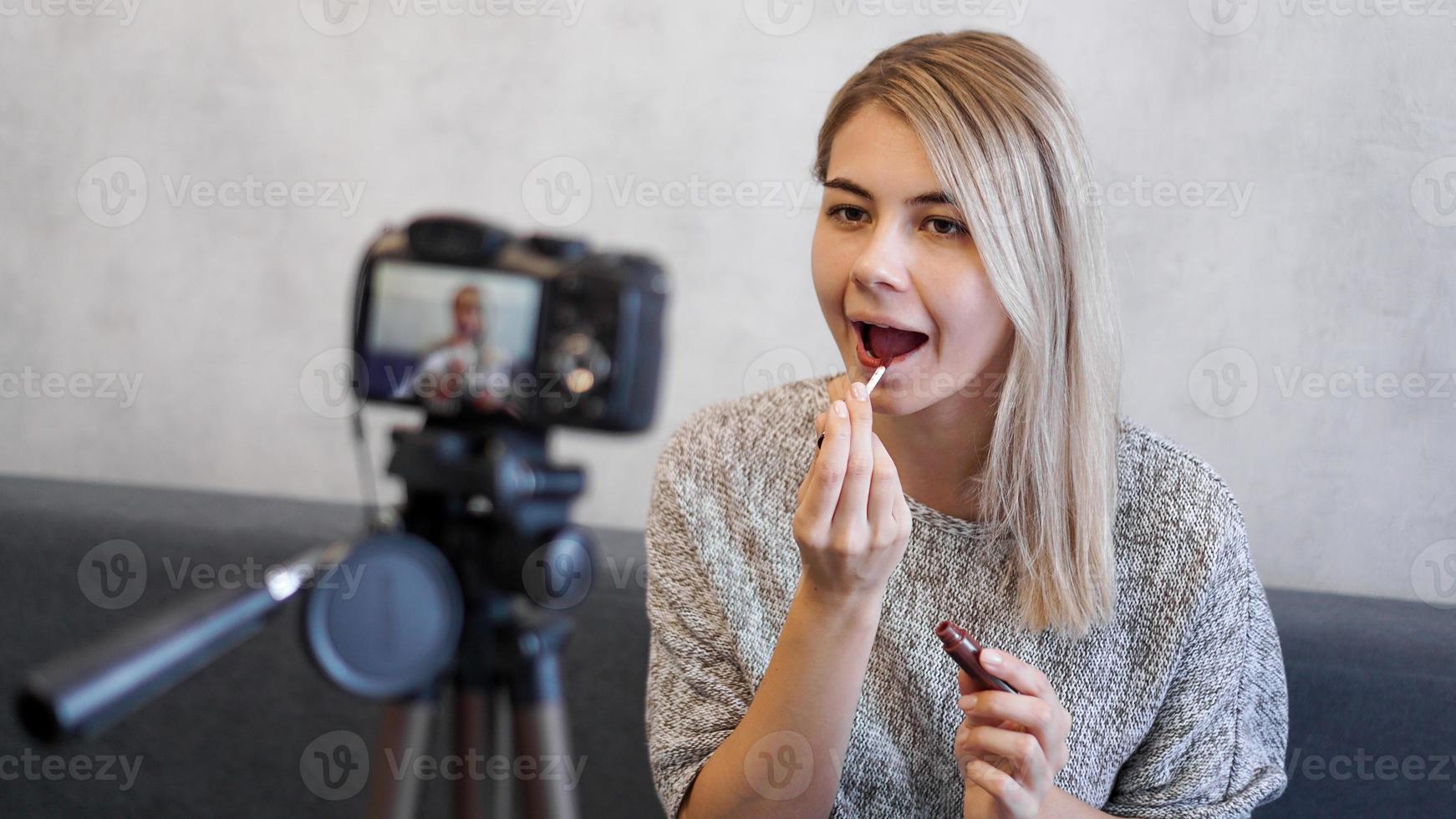 A beauty blogger or video blogger tells and shows how to do makeup photo