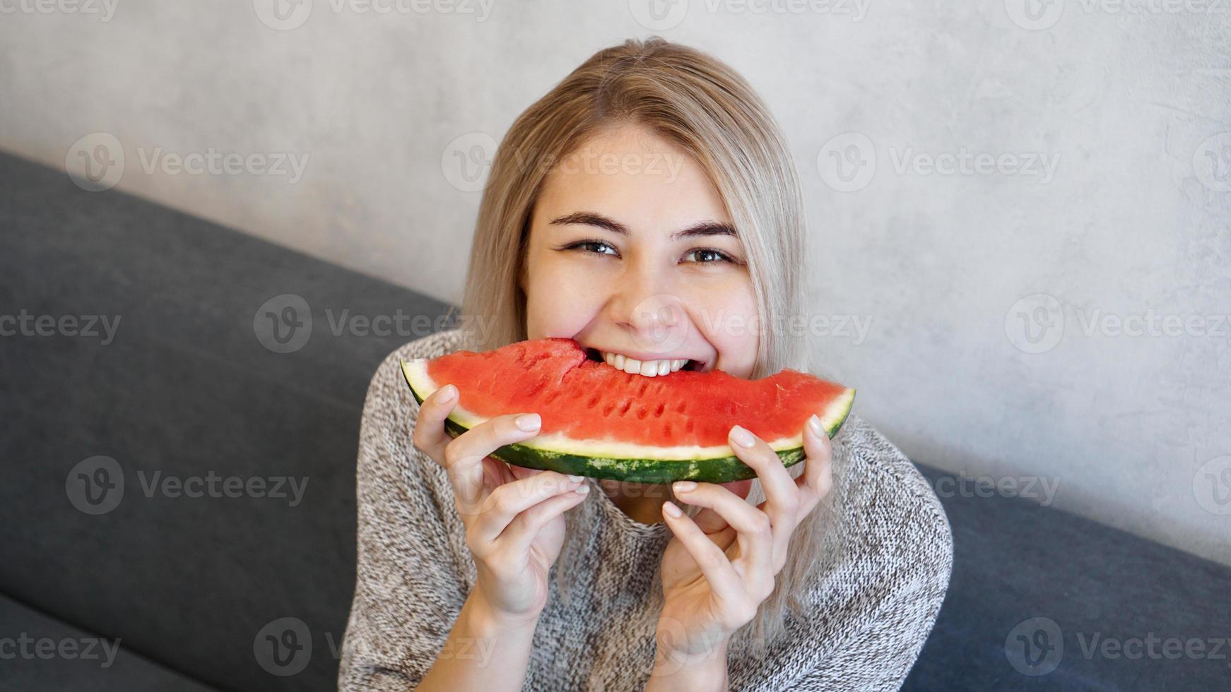 atractiva joven comiendo sandía. mujer en casa foto