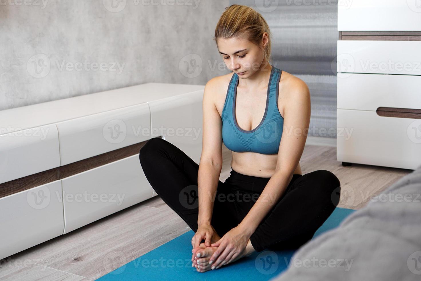 feliz fitness mujer yoga relajarse meditación en pose de mariposa en casa. foto