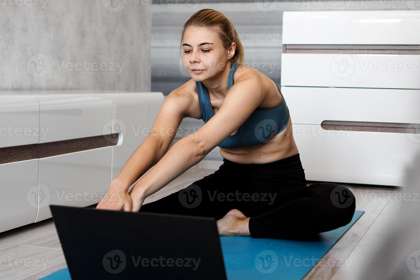 Woman in sportswear watching online video on laptop photo