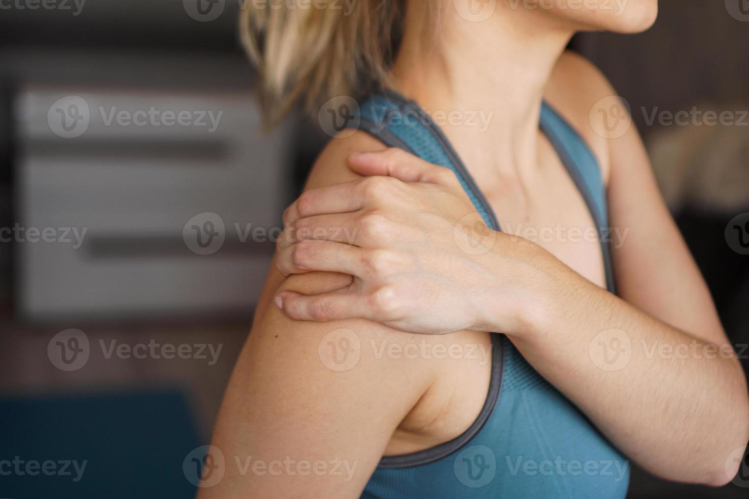 Closeup on fitness woman having pain in shoulder photo