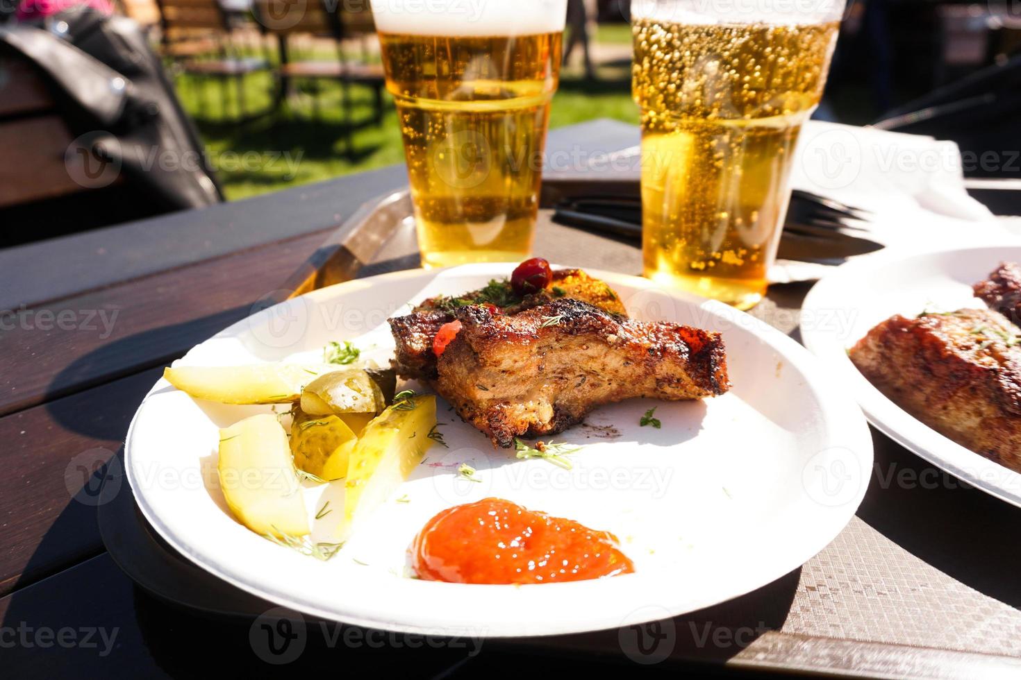 Pork ribs on a tray and light beer. Street food. Festival food photo