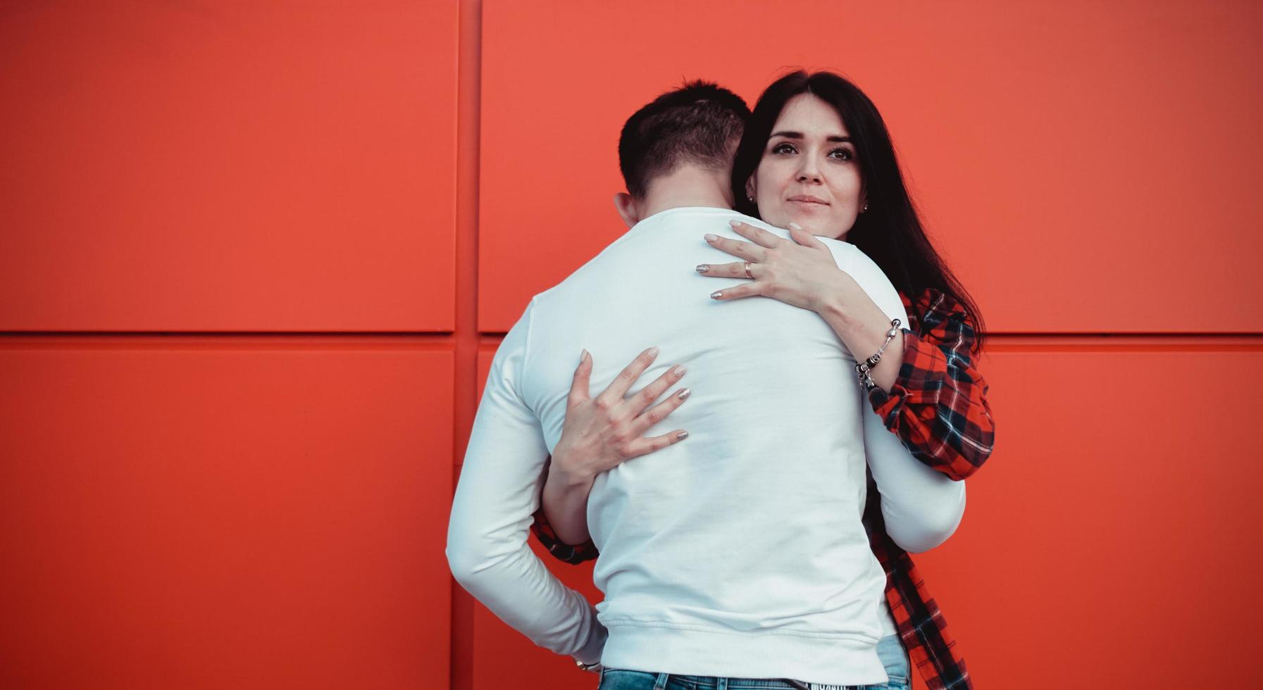 pareja de citas y abrazos en el amor en un día soleado - fondo rojo foto