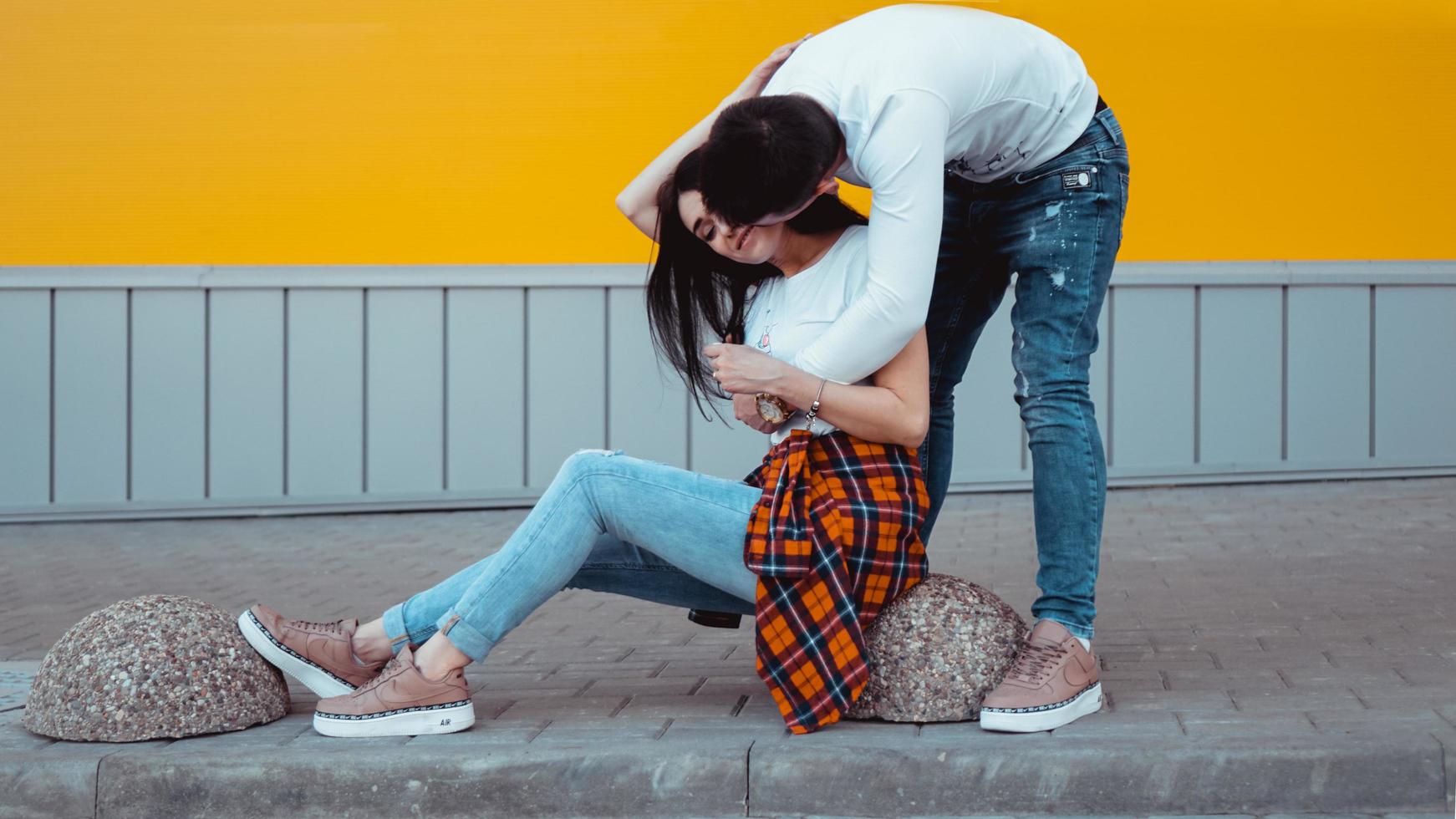 Young lovely couple posing together and hugging over yellow background photo