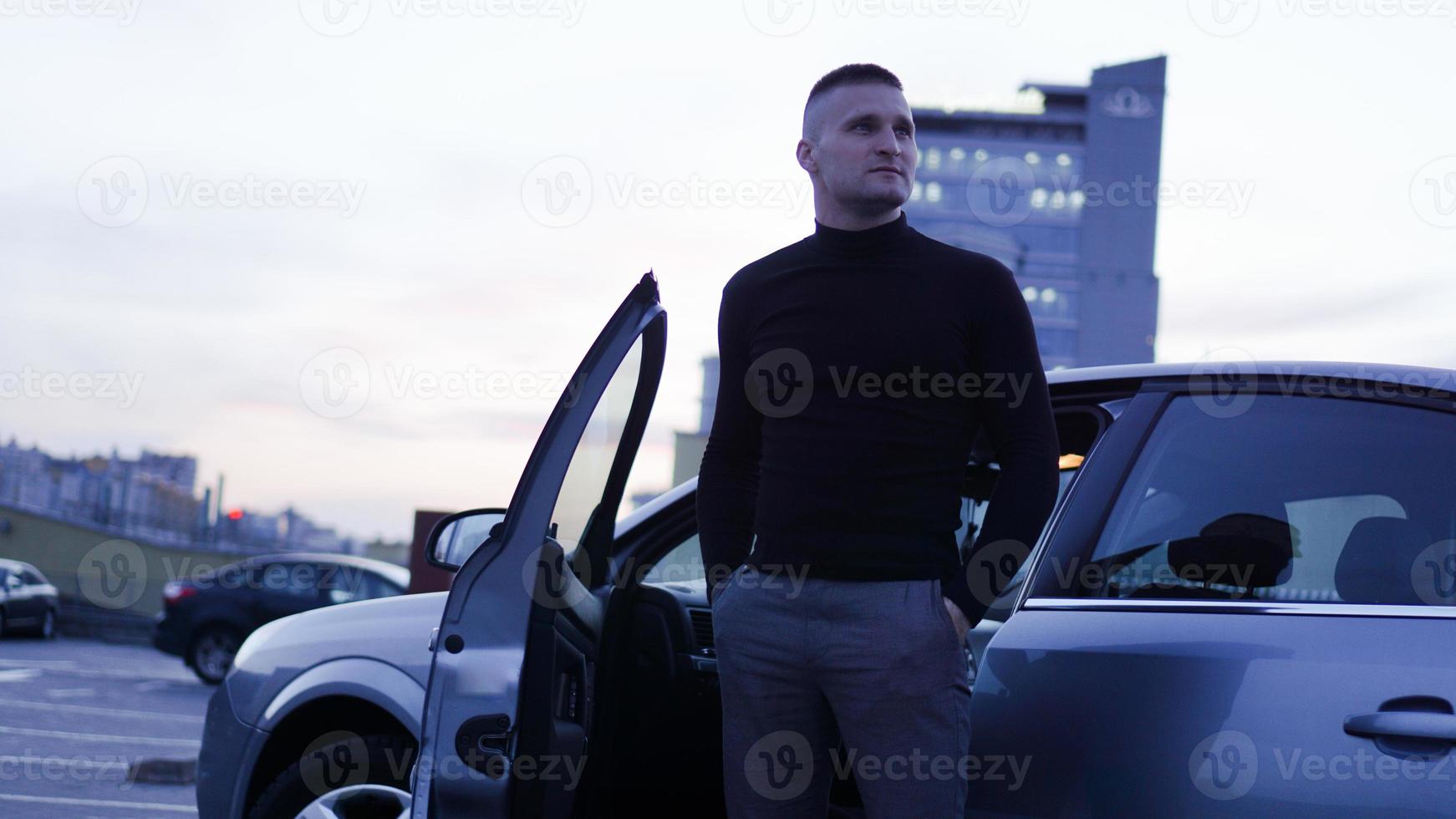 apuesto hombre de negocios cerca del coche en la ciudad foto