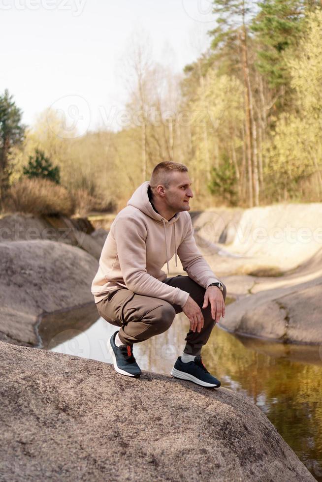 Young man in a comfortable suit at the edge of a rowing canal photo