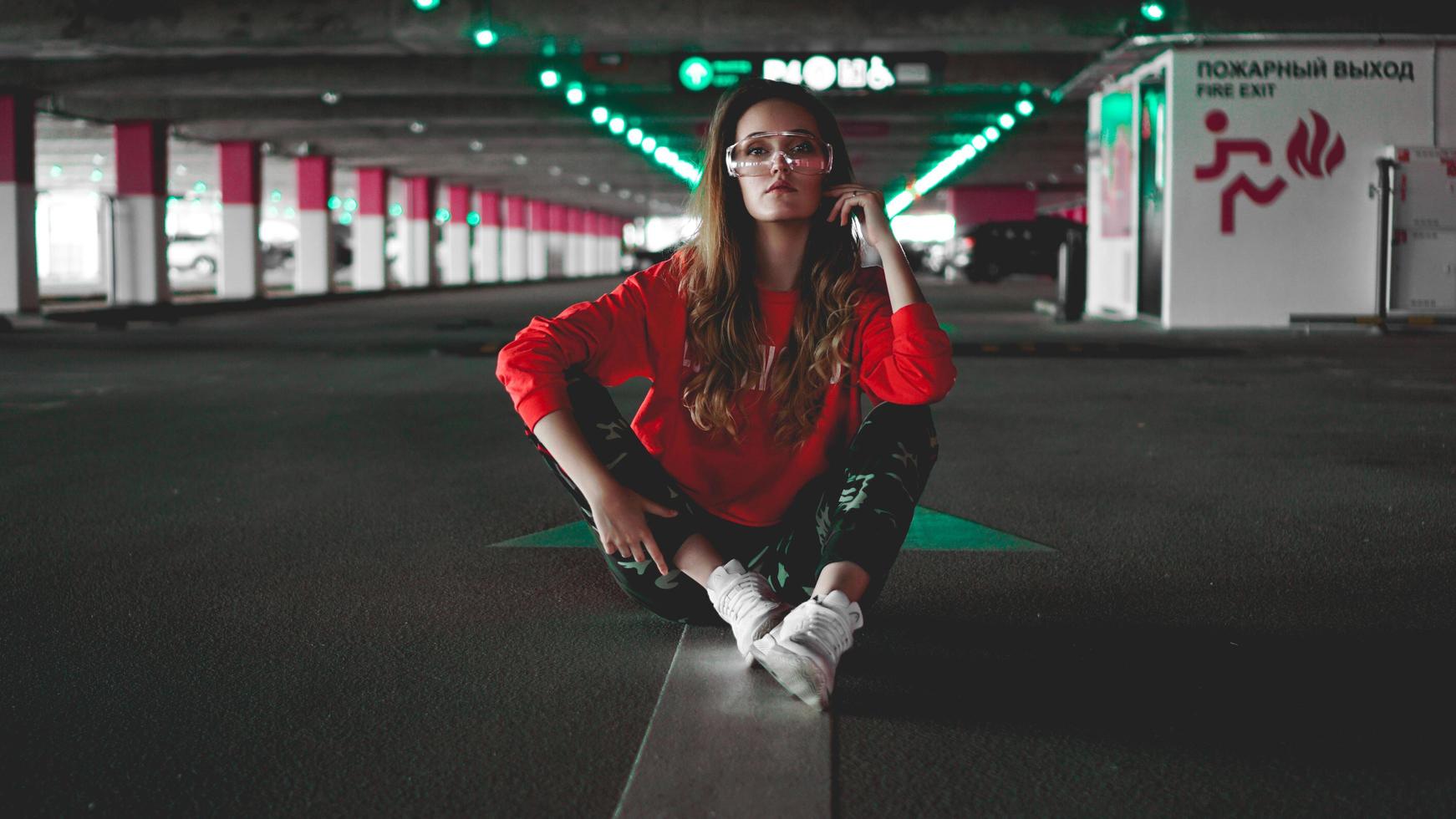 Pretty young woman sitting on car parking photo