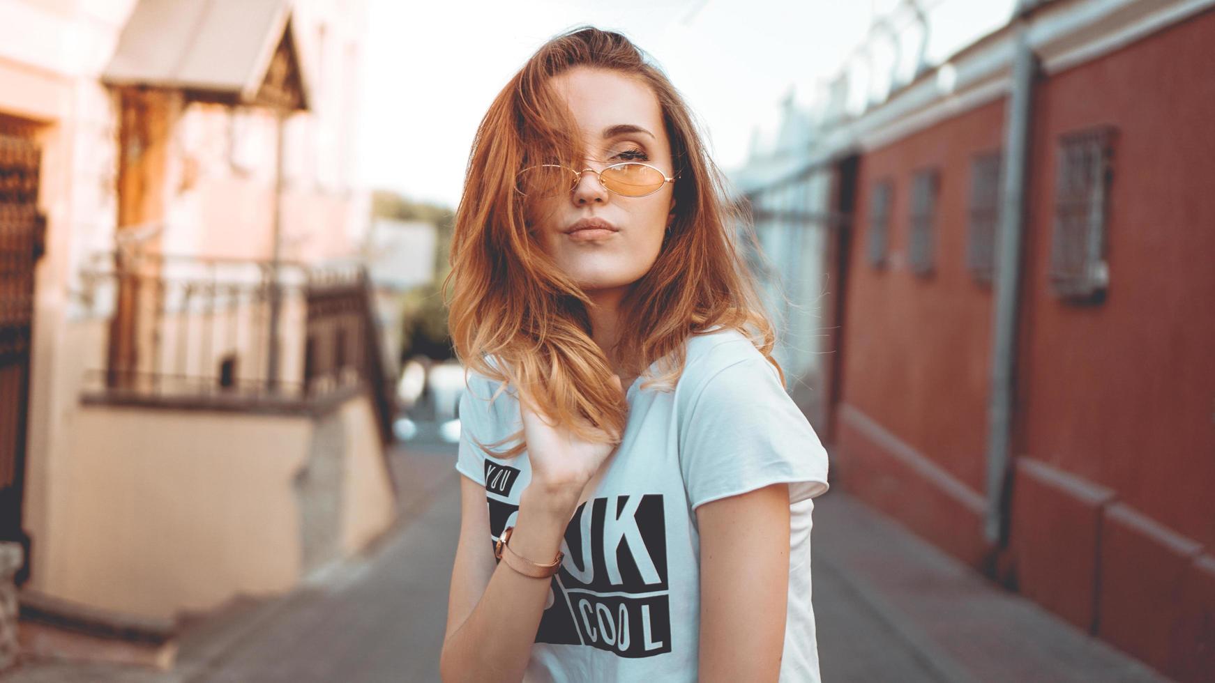 Retrato de moda elegante mujer bonita en gafas de sol posando en la ciudad foto