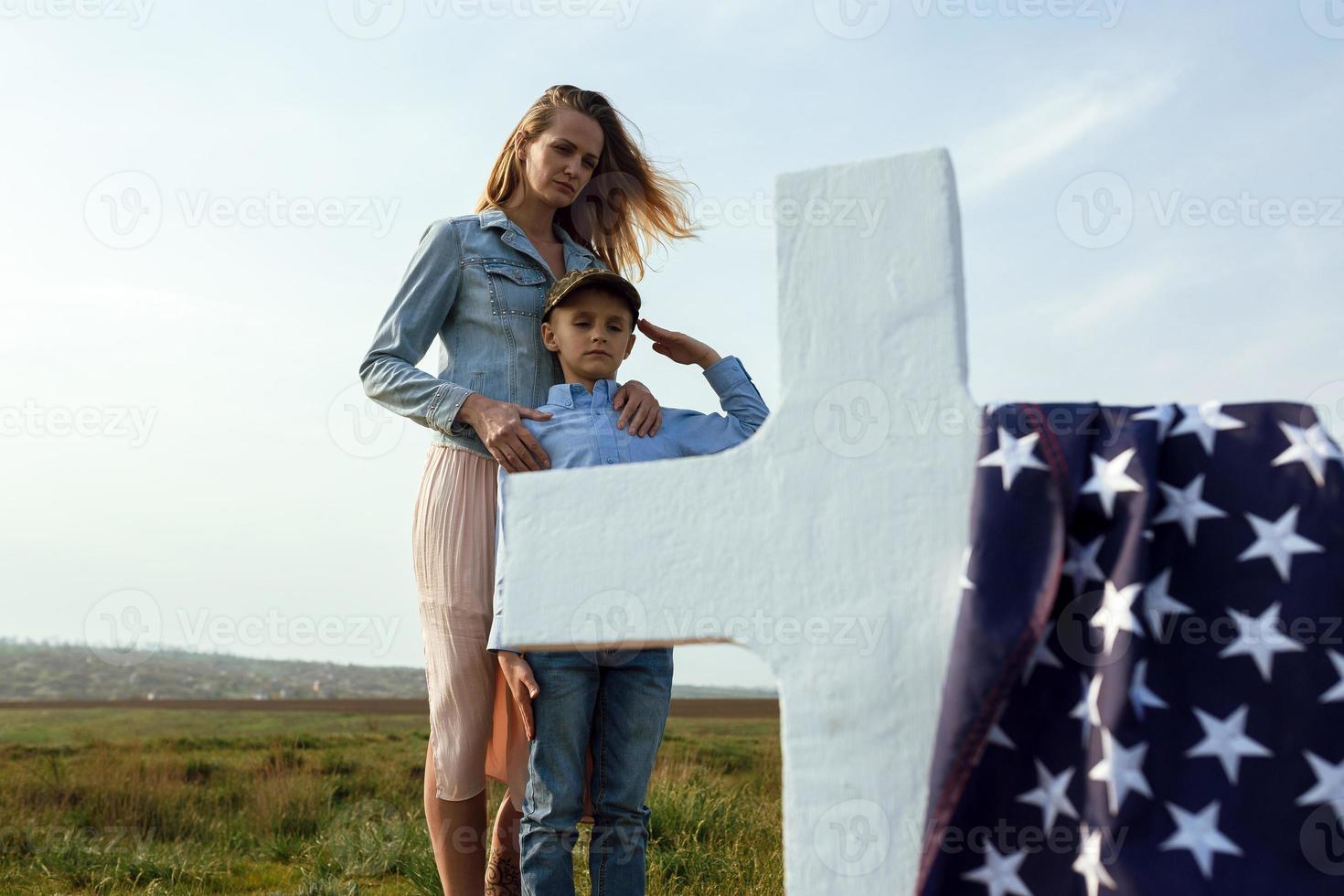 Mom and son visited the grave of the father on the memorial day photo