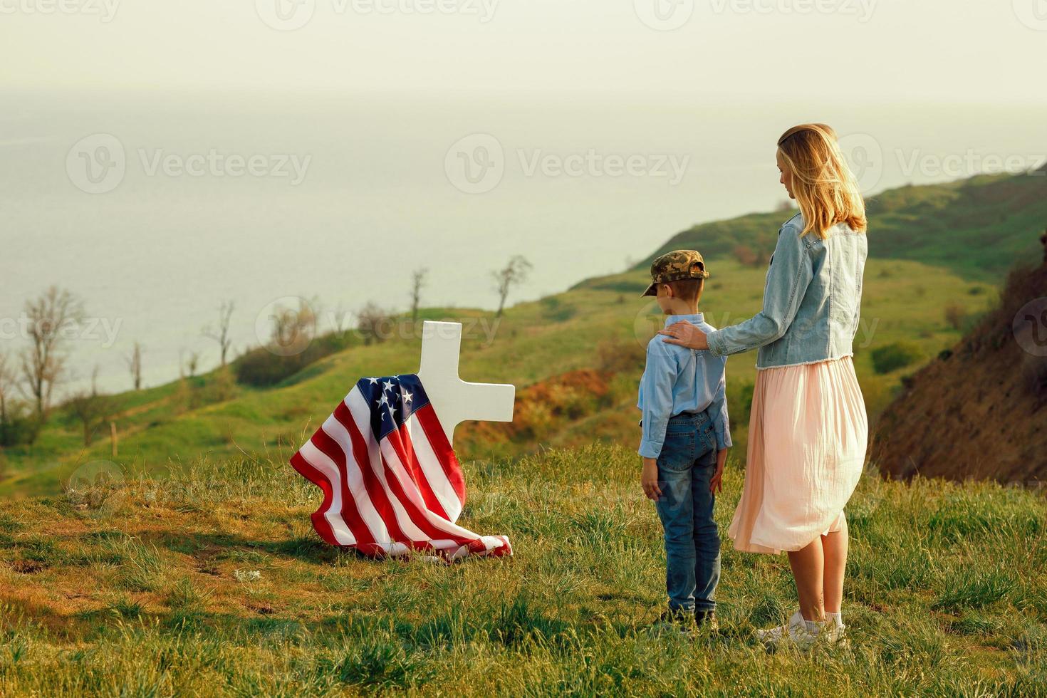 Mom and son visited the grave of the father on the memorial day photo