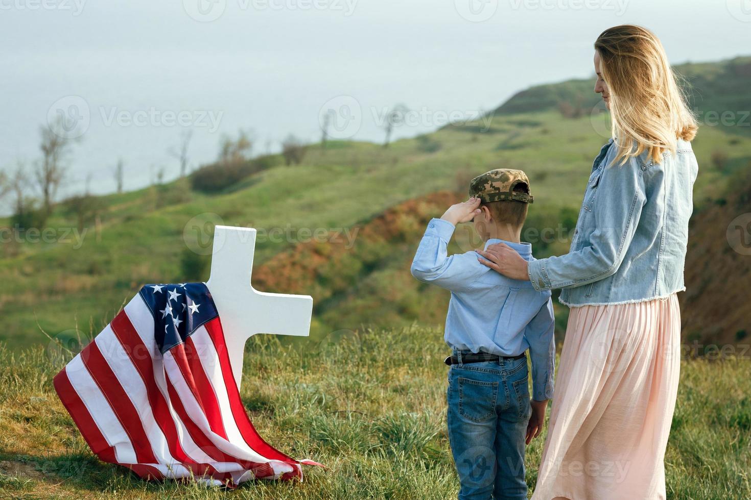 Mom and son visited the grave of the father on the memorial day photo