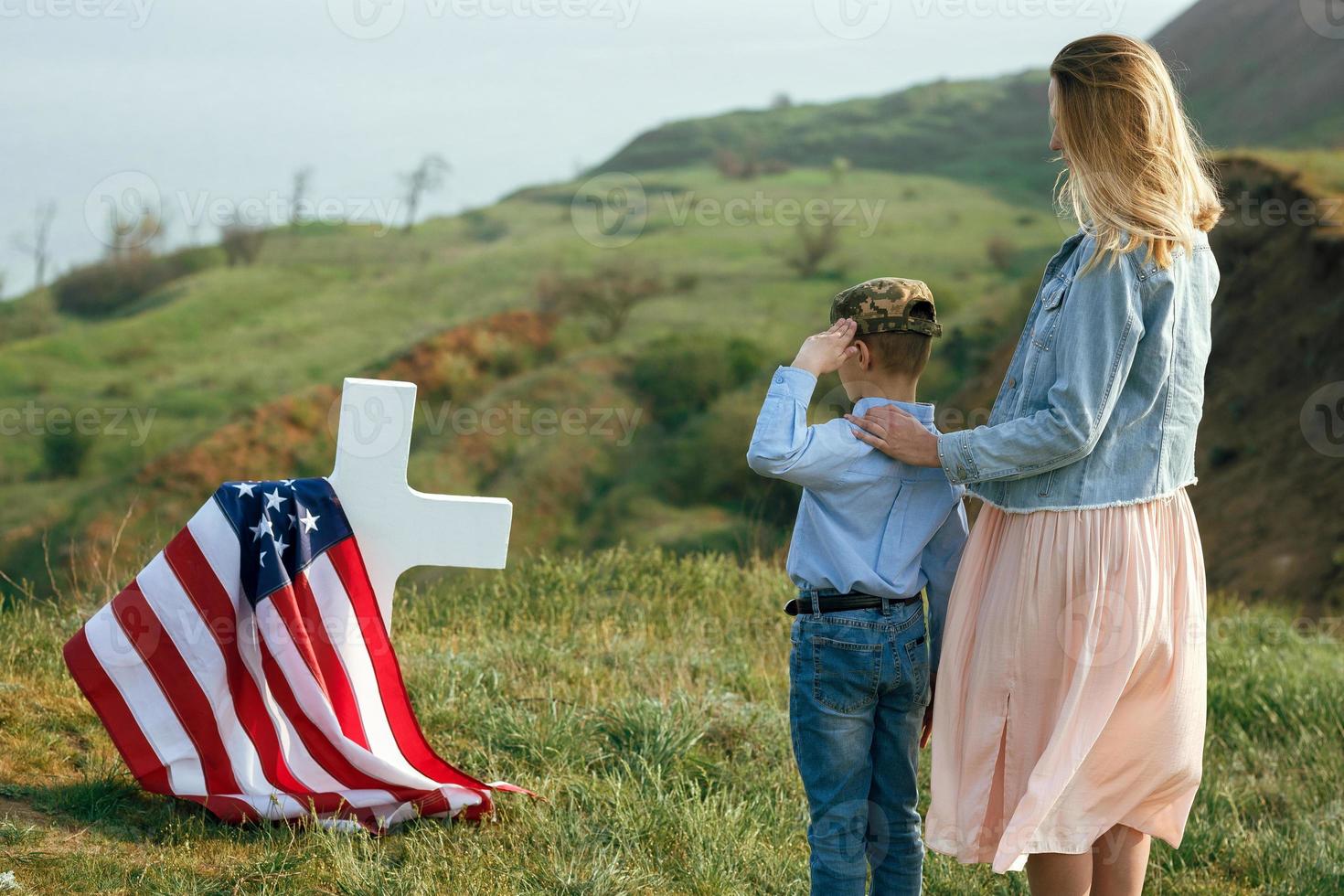 Mom and son visited the grave of the father on the memorial day photo