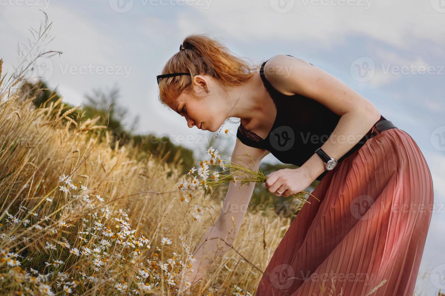 Young woman enjoying nature and sunlight in straw field photo