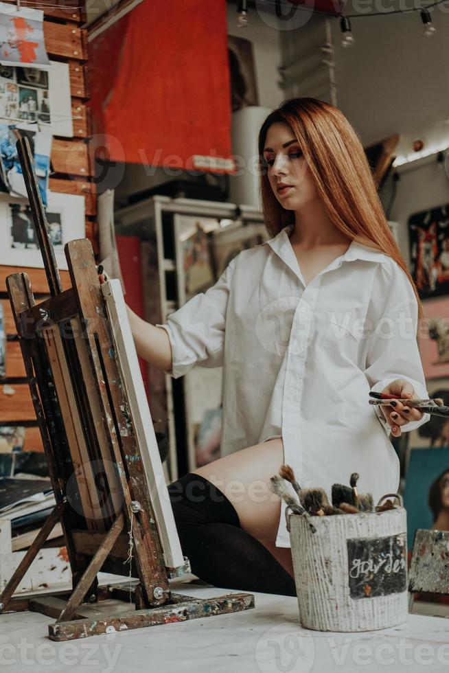 Artista femenina con pincel en taller de arte foto