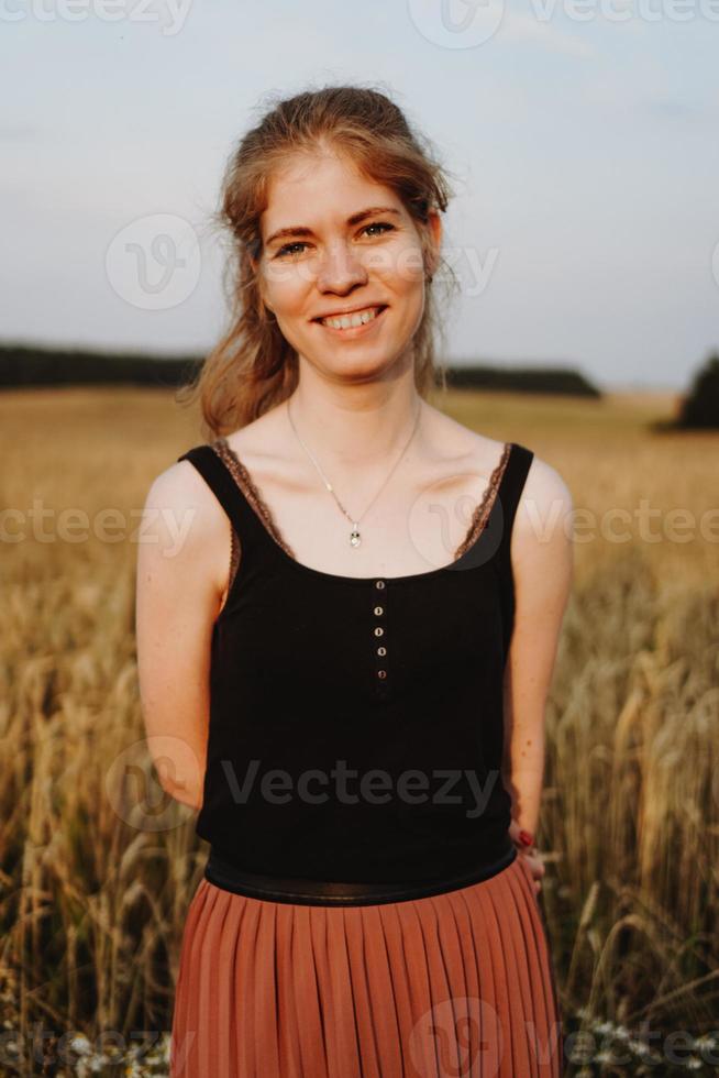 Young woman enjoying nature and sunlight in straw field photo