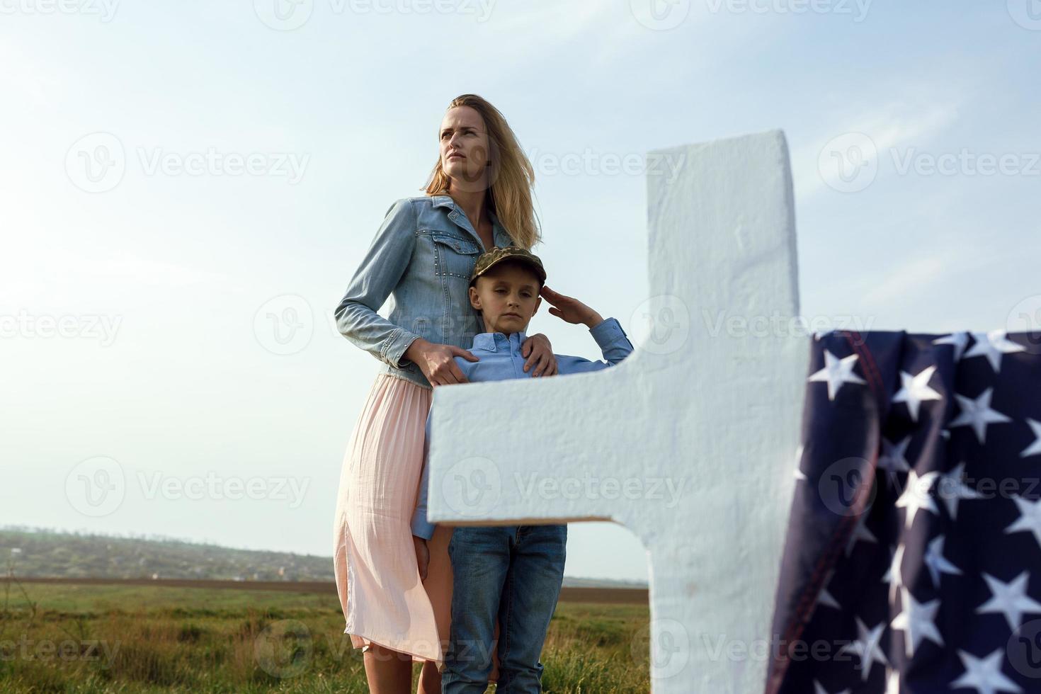 Mom and son visited the grave of the father on the memorial day photo