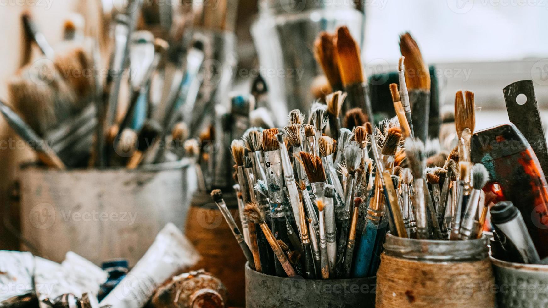 Table with brushes and tools in art workshop. Background. photo