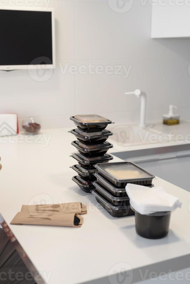 Close up of disposable boxes with food, sorted by meals photo