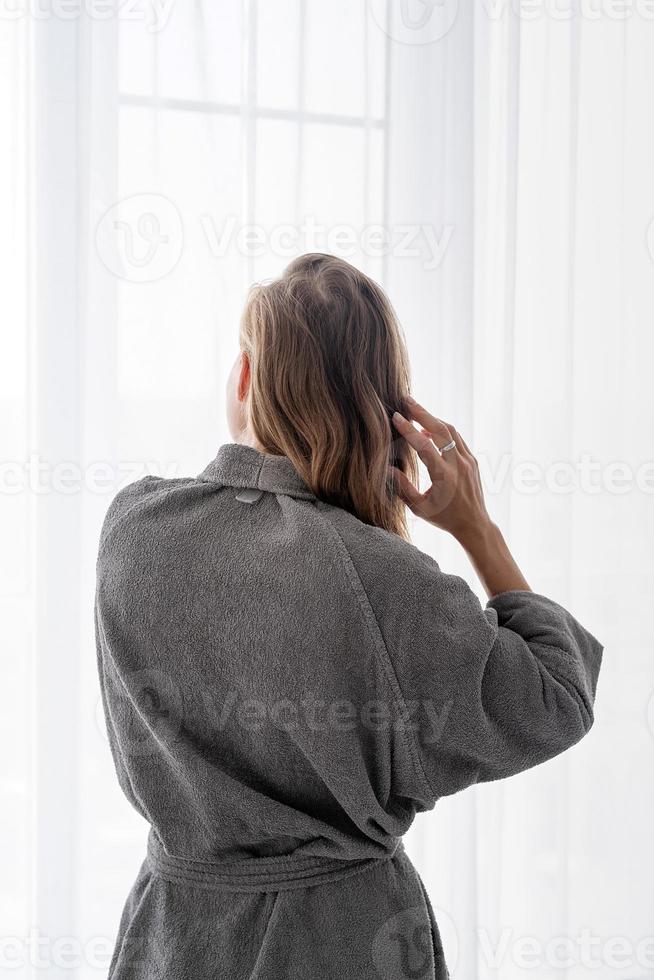 mujer joven feliz aplicando mascarilla para el cabello foto