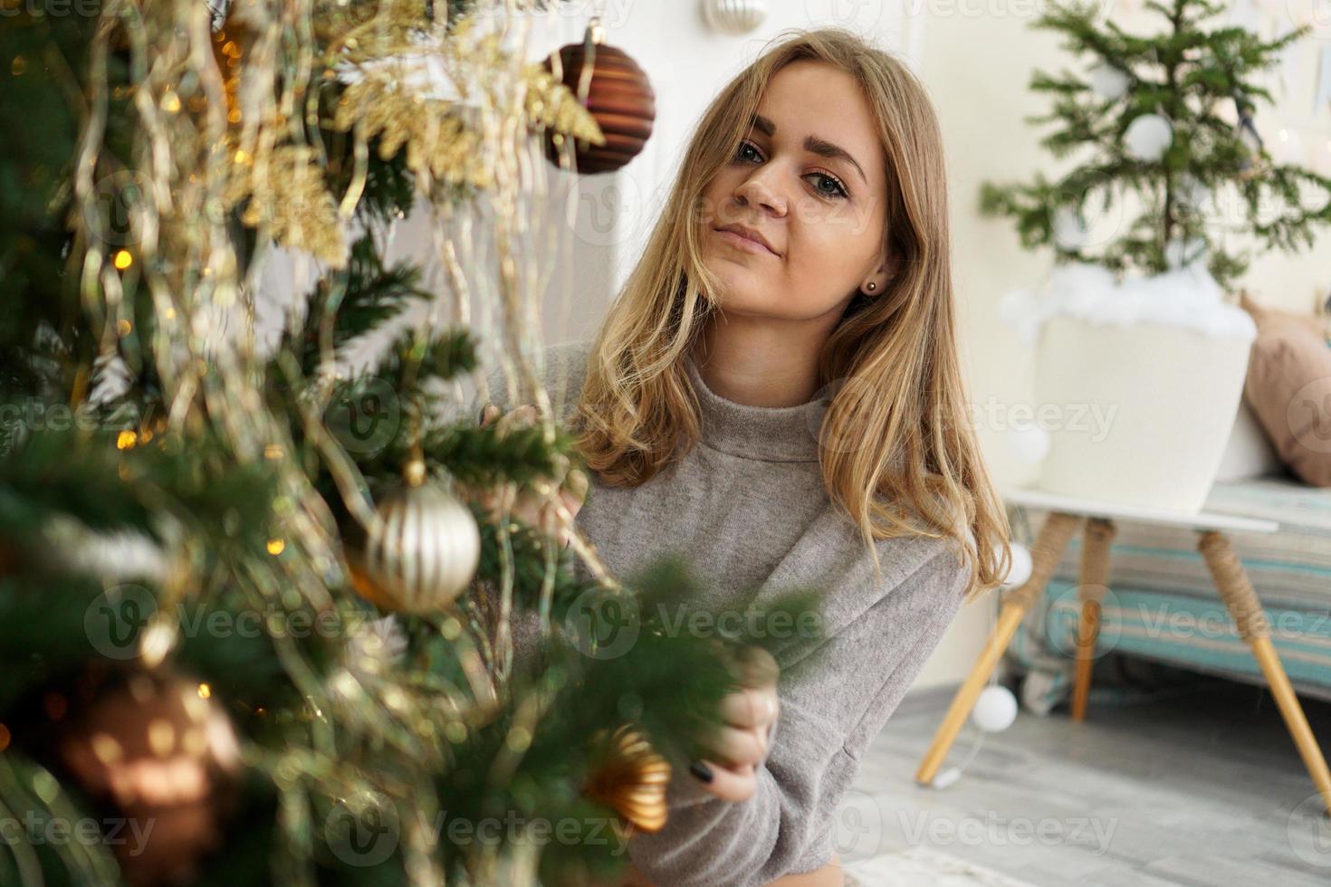 hermosa joven decorando un árbol de navidad foto