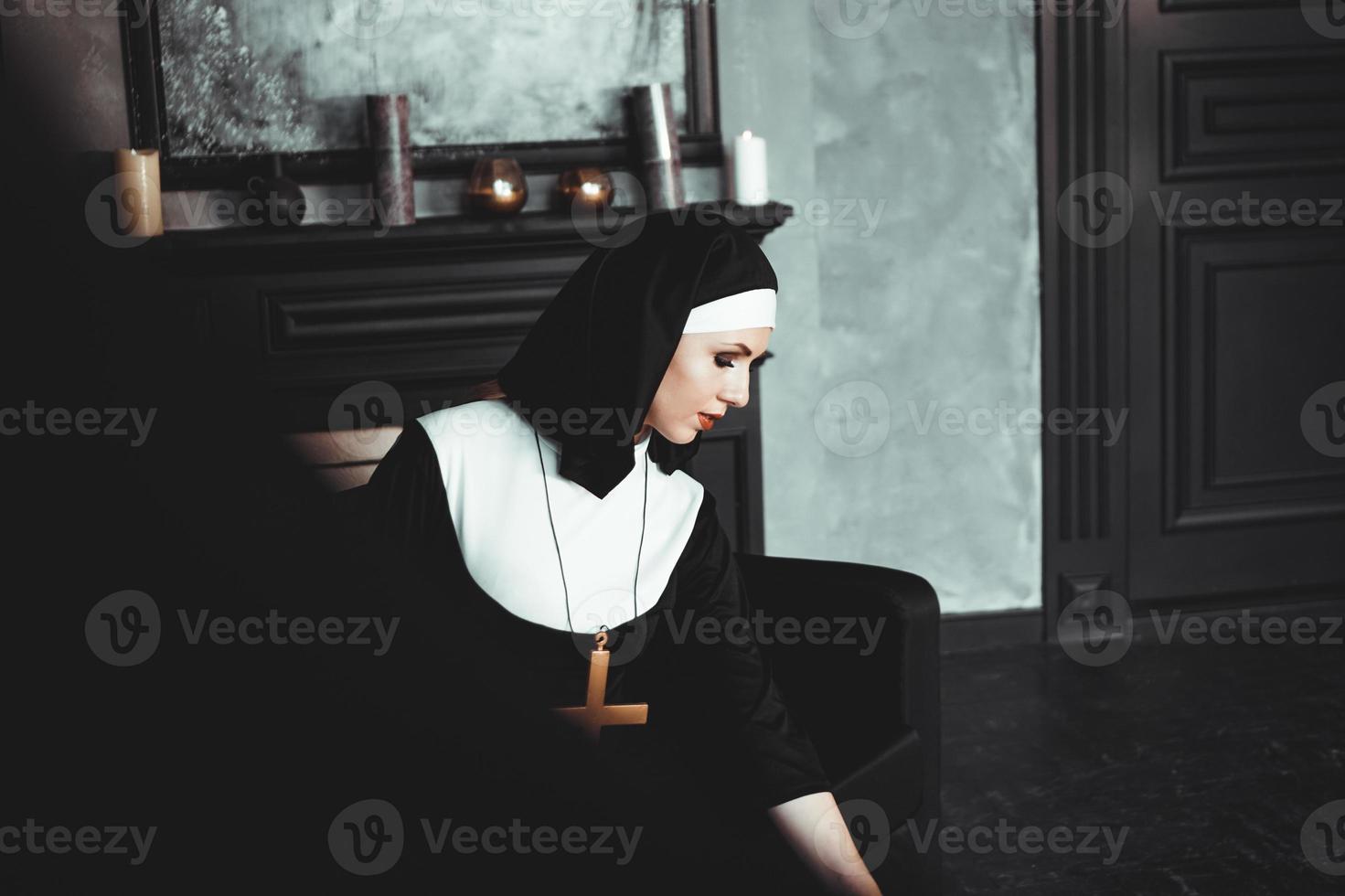 Sexy nun prays indoor. Beautiful young holy sister. photo