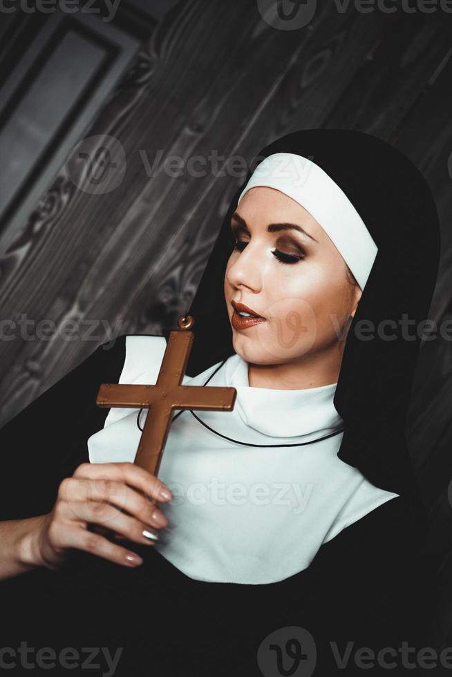 Sexy nun prays indoor. Beautiful young holy sister. photo