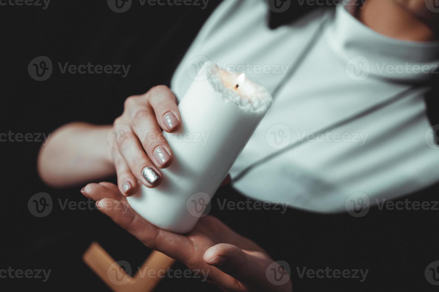 joven monja católica sostiene una vela en sus manos foto