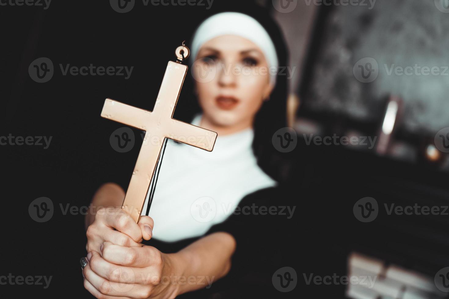 monja sosteniendo una cruz. el concepto de religión. foto