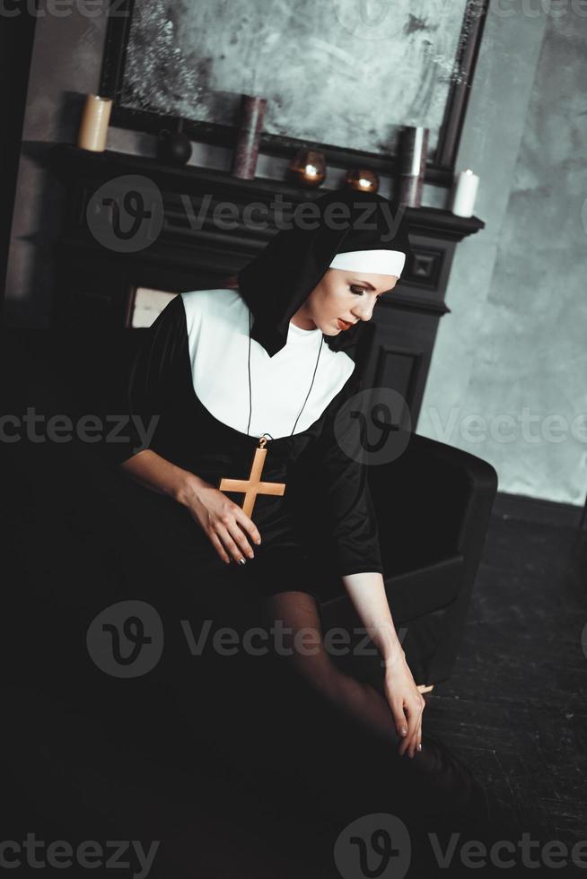 Sexy nun prays indoor. Beautiful young holy sister. photo