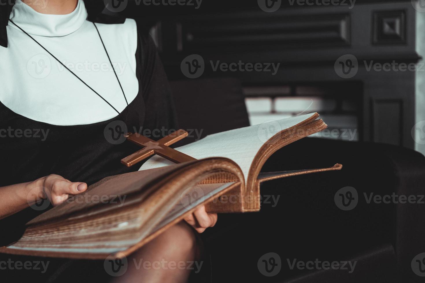 Nun in religion black suit holds Bible. Religion concept photo