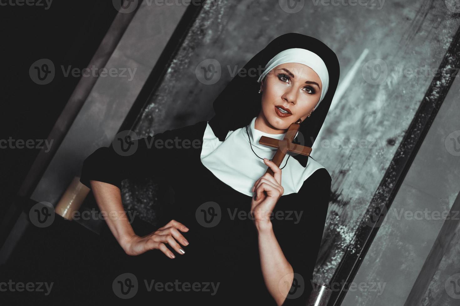 Sexy nun prays indoor. Beautiful young holy sister. photo