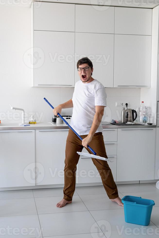 hombre limpiando casa con trapeador foto