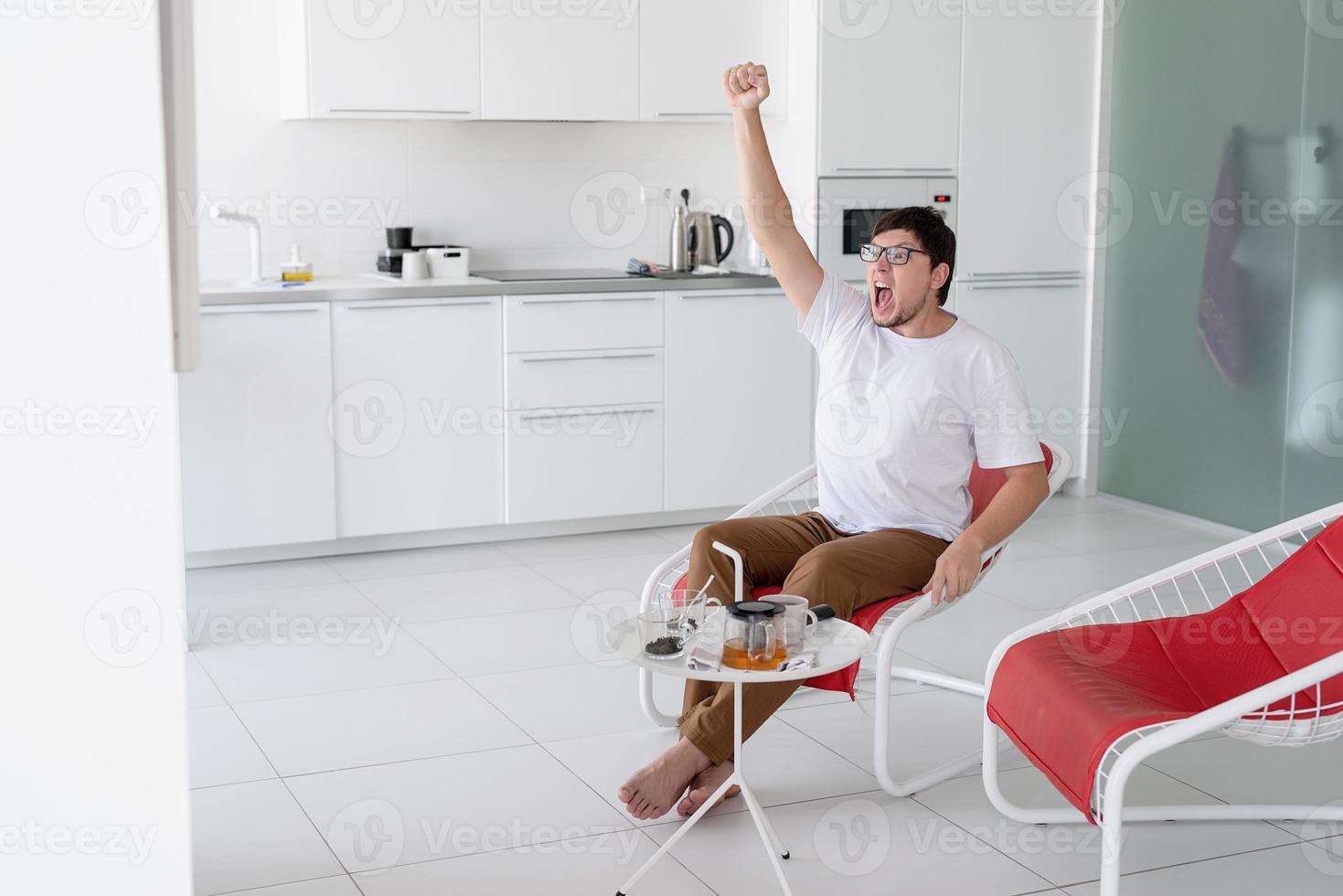 Young man watching sports game, cheering and screaming photo