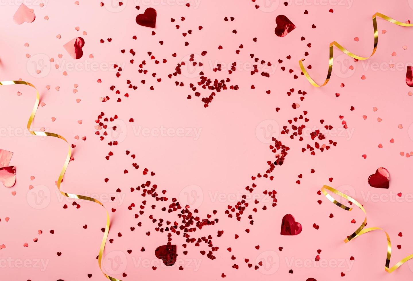 Red heart shape confetti heart top view flat lay on pink background photo