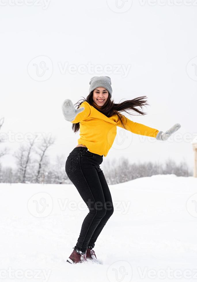 mujer joven, morena, juego, con, nieve, en el estacionamiento foto