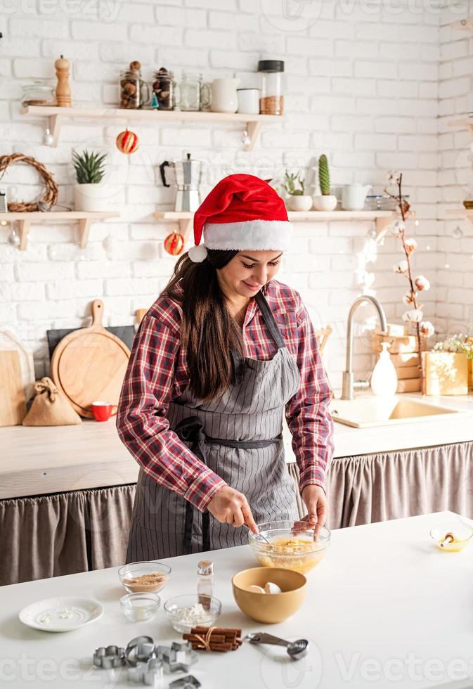 Young latin woman whisking eggs cooking at the kitchen photo