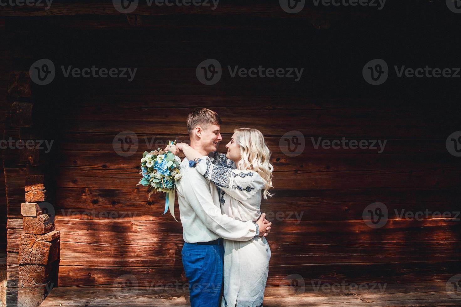 pareja casada fuera de una casa de madera foto